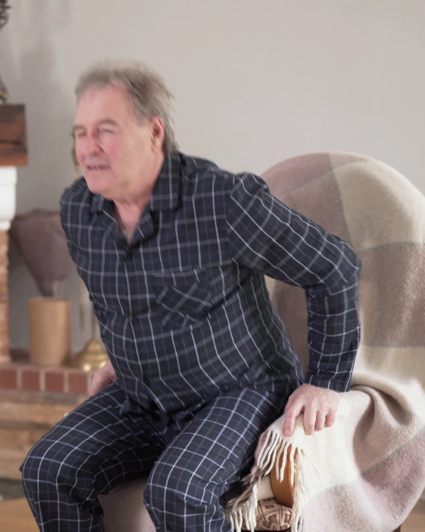 Les deux mains sur les bras du fauteuil, il pousse pour se relever, en deux temps